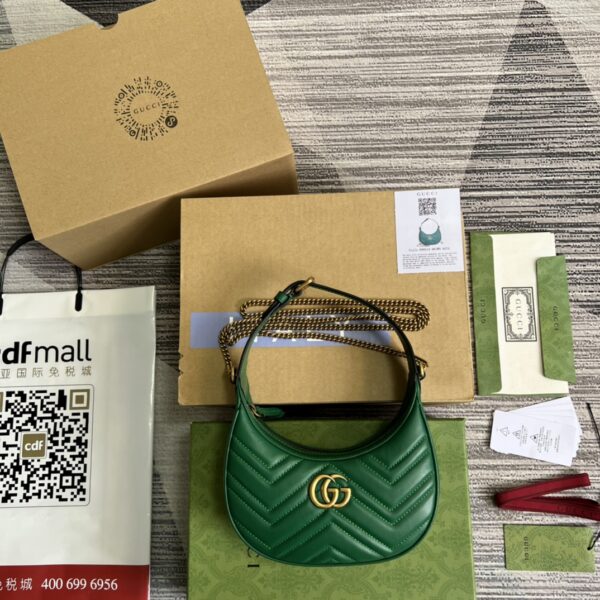 This mini handbag features a crescent-shaped silhouette and luxurious black leather, exuding a rich vintage style.